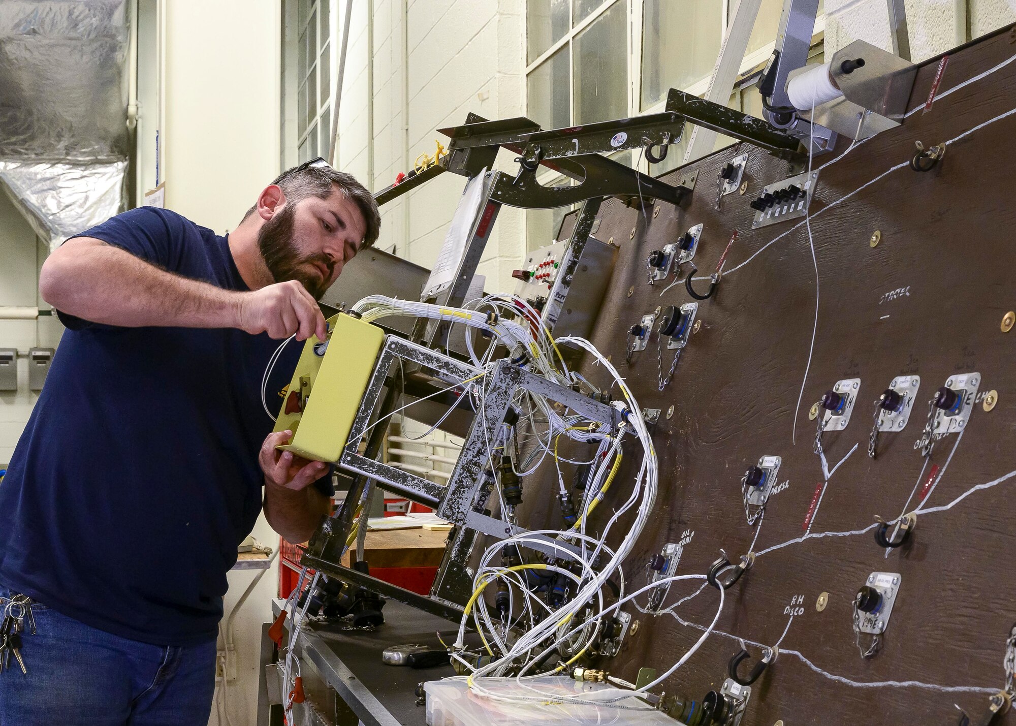 Dave Embler, Contract Field Team member, assembles and tests the wiring harness for a refurbished Quick Engine Change kit QEC on a wiring board prior to installation, Dec. 29, 2020, at Little Rock Air Force Base, Ark. The facility produces all C-130H Hercules 3.5 engine modifications and 54H60-117 propeller overhauls for Air Force Reserve Command and various Air National Guard units. (U.S. Air Force Reserve photo by Maj. Ashley Walker)