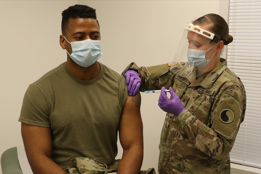 Capt. Wilifred Hale receives a COVID-19 vaccination from Sgt. Anna Carter Dec. 31, 2020, at Fort Pickett, Virginia.