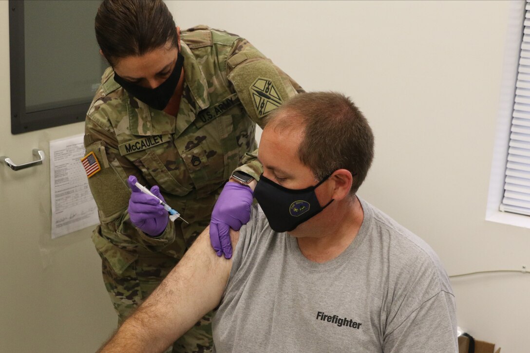 Danny Clary receives a COVID-19 vaccination from Staff Sgt. Jennifer McCauley Dec. 31, 2020, at Fort Pickett, Virginia.