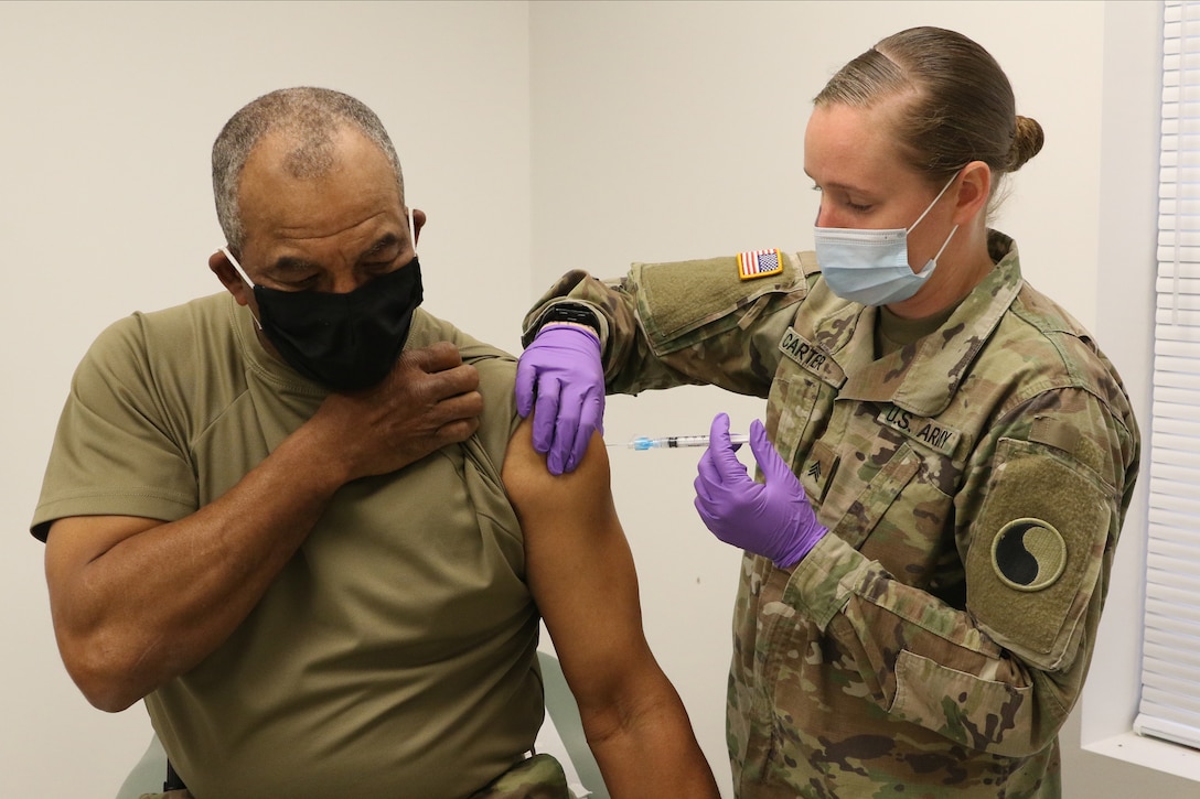Command Sgt. Maj. Ronald Howell receives a COVID-19 vaccination from Sgt. Anna Carter Dec. 31, 2020, at Fort Pickett, Virginia.