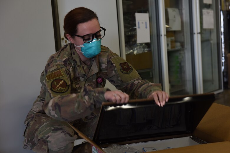 Senior Airmen Lauren Lacaprara, left, and Bayli Moore, 341st Healthcare Operations Squadron medical material technicians, open a shipment of delivered Maderna COVID-19 vaccines, Dec 30, 2020, at Malmstrom Air Force Base, Mont.