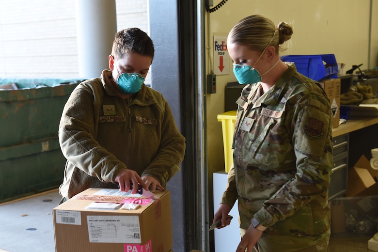 Staff Sgt. Michelle Krous, 341st Healthcare Operations Squadron NCO in charge of acquisitions, opens a box of delivered Maderna COVID-19 vaccines, Dec. 30, 2020 at Malmstrom Air Force Base, Mont.