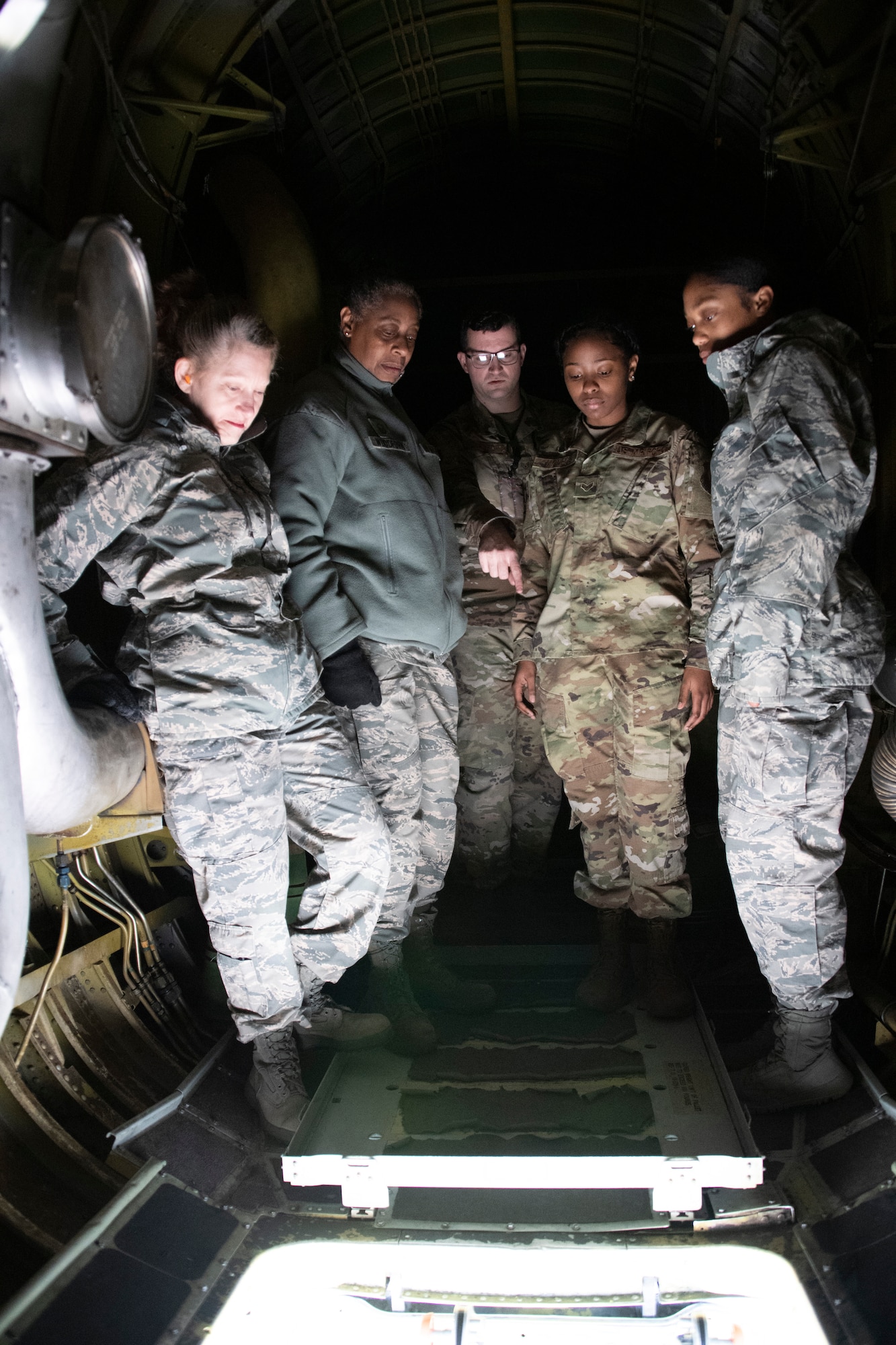 Airmen look through a hatch on a B-52
