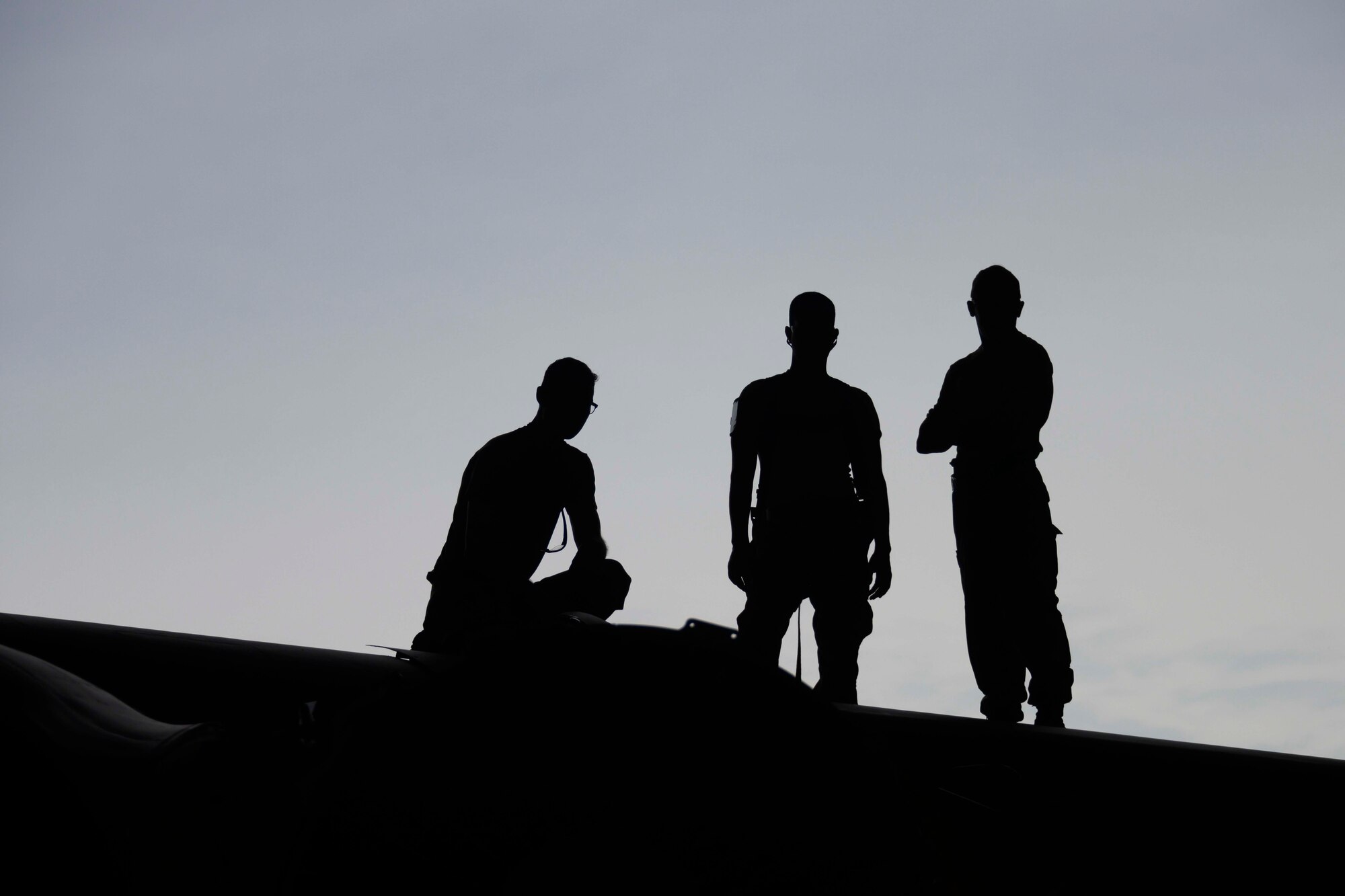 Silhouette of three Airmen on wing of a B-52
