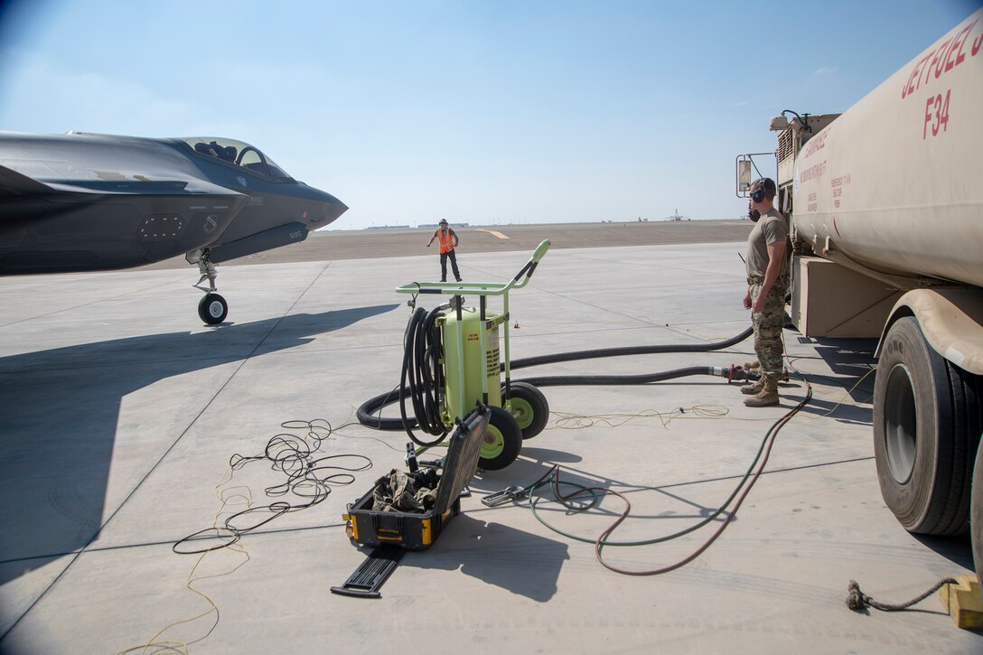 Members of the 380th Expeditionary Aircraft Maintenance and Logistics Readiness Squadrons standby as an F-35A Lightning II taxis toward a hot pit refueling point on the Al Dhafra Air Base flightline, United Arab Emirates, Jan. 29, 2020 . A hot pit refueling is the process in which ground crew Airmen refuel an aircraft while its engines are still running, minimizing the time required to get the aircraft airborne again. This capability enhances the readiness of the wing and ability to execute the air tasking order. (U.S. Air Force photo by Staff Sgt. Anna-kay Ellis)