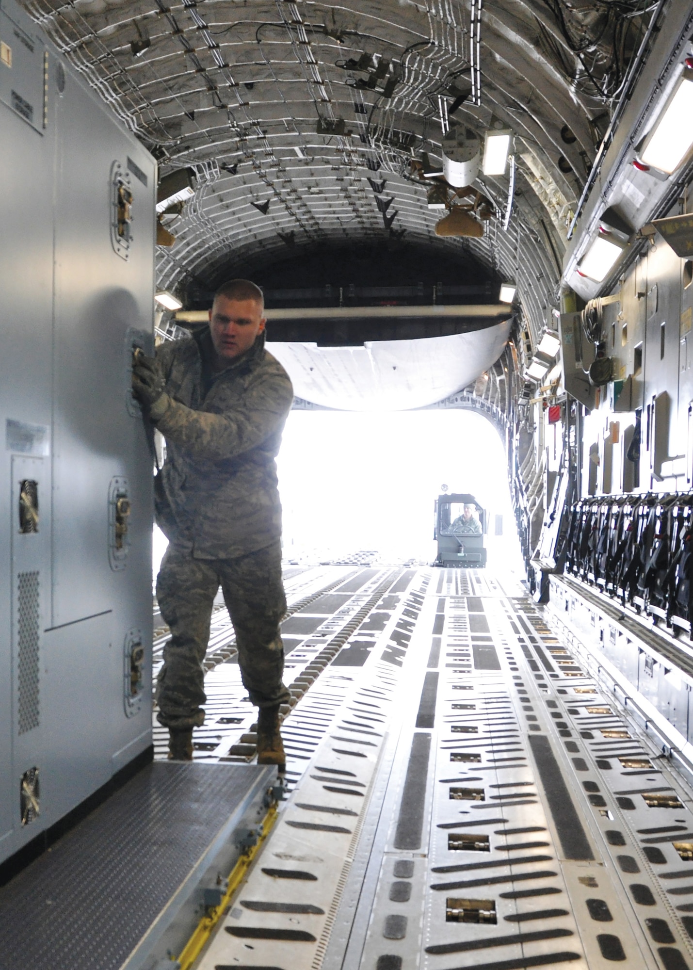 Staff Sgt. Dakota Coniglio, ramp operations specialist with the 87th Aerial Port Squadron, pushes an air transportable galley-lavatory onto a C-17 Globemaster III at Wright-Patterson Air Force Base, Ohio. The ramp operations duty section works closely with the load planning duty section, both part of the aerial port squadron, to safely and quickly airlift cargo and people in support of the Air Force mission. (U.S. Air Force photo/1st Lt. Rachel Ingram)