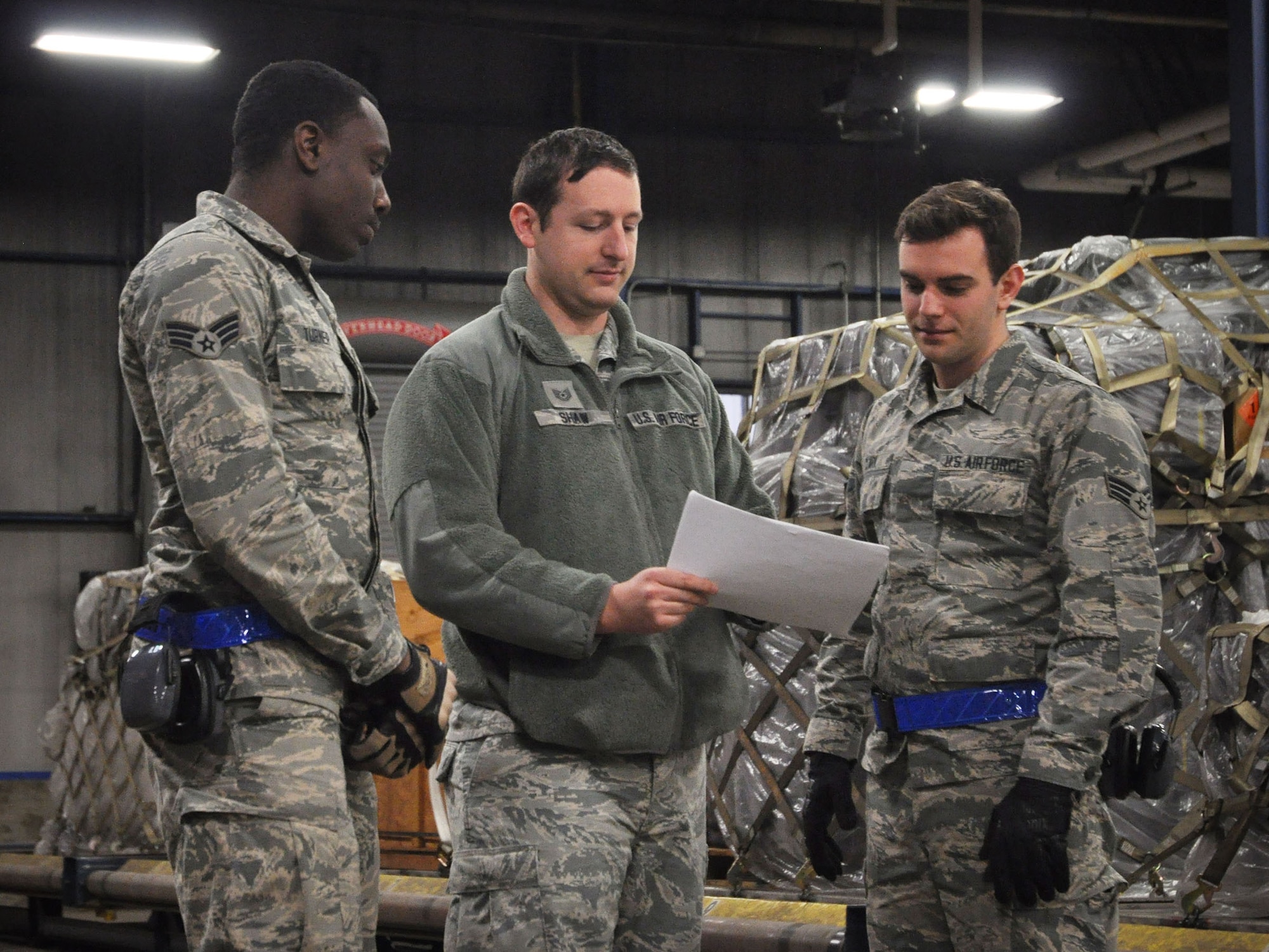 Tech Sgt. Taylor Shaw, load planner with the 87th Aerial Port Squadron, reviews a load plan with Senior Airmen Jason Turner and Gabriel Clark, both ramp operations specialists with the 87th APS.  The load plan is an essential tool in making cargo is balanced, safe and air-worthy before for any C-17 Globemaster III flight.  (U.S. Air Force photo by Senior Airman Angela Shay)