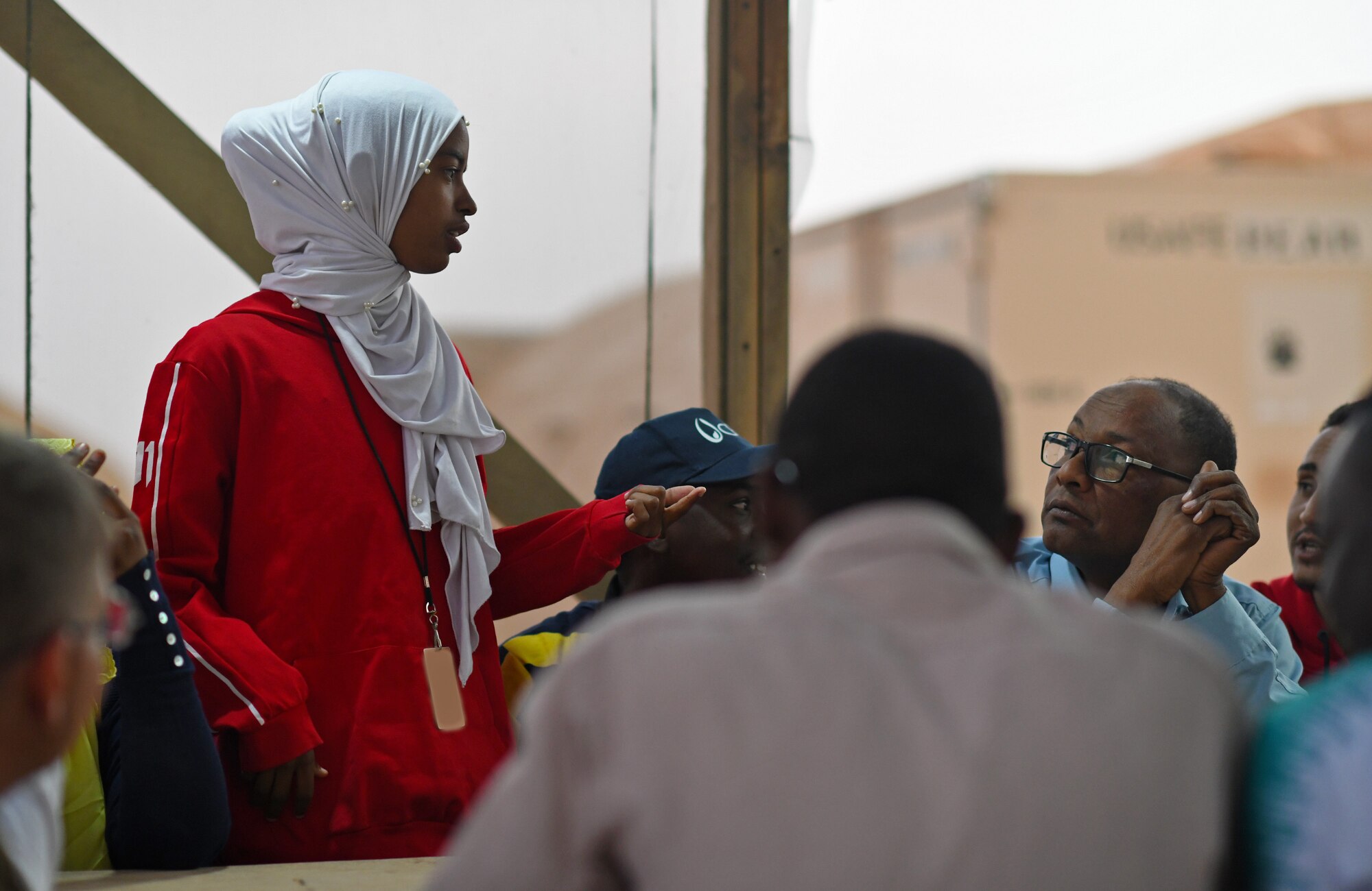 A member of the local English Discussion Group talks with U.S. military personnel at Nigerien Air Base 201, Niger, Feb. 1, 2020. Invited on base by members of the U.S. Army 443rd Civil Affairs Battalion Civil Affairs Team 219, the group continually improves their language skills by talking to native English speakers. (U.S. Air Force photo by Tech. Sgt. Alex Fox Echols III) (This photo has been altered for security purposes by blurring out identification badges.)
