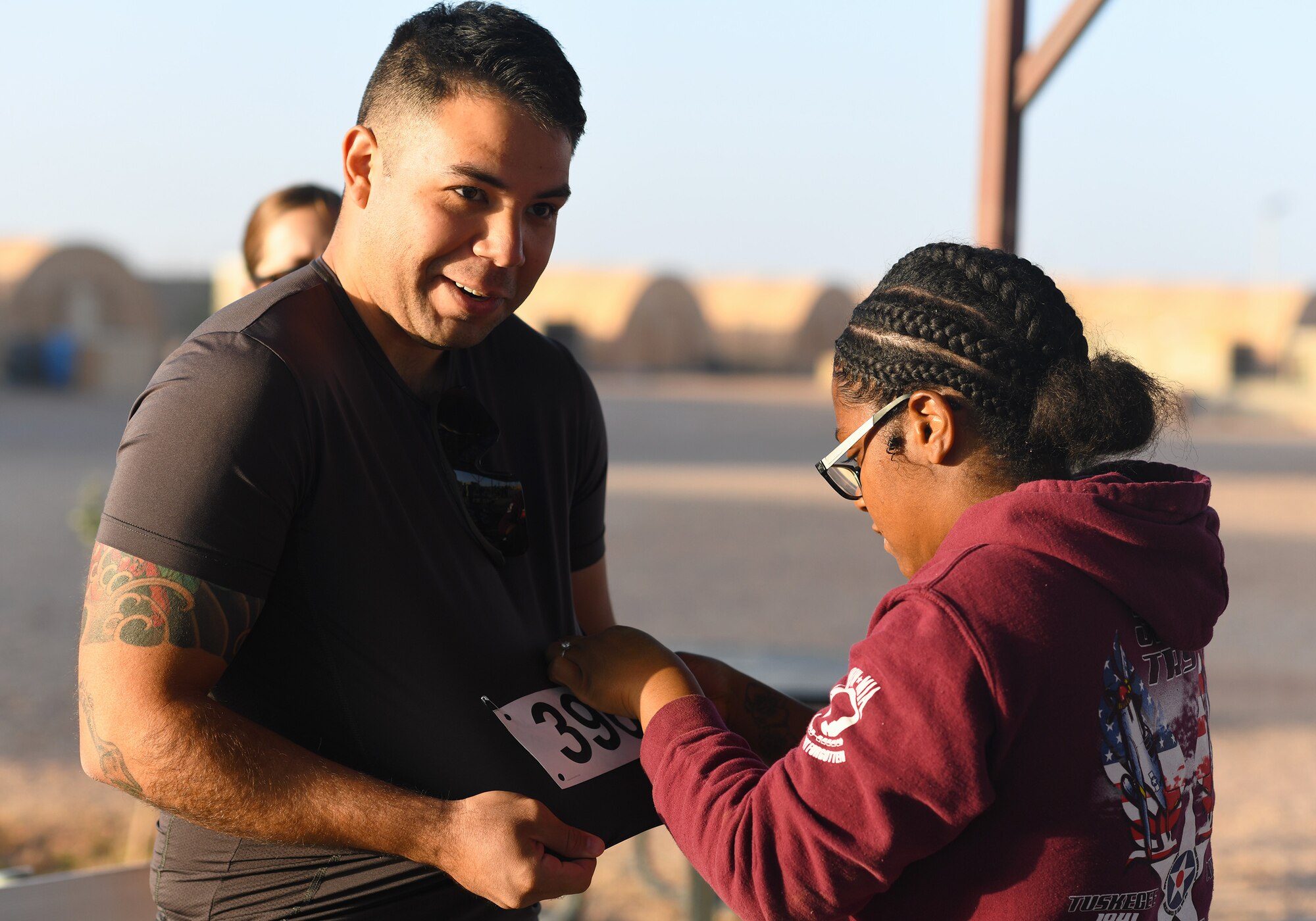 A color run participant receives his number from an event coordinator at Nigerien Air Base 201, Niger, Feb. 2, 2020. More than 30 runners and volunteers participated in the event. (U.S. Air Force photo by Tech. Sgt. Alex Fox Echols III)
