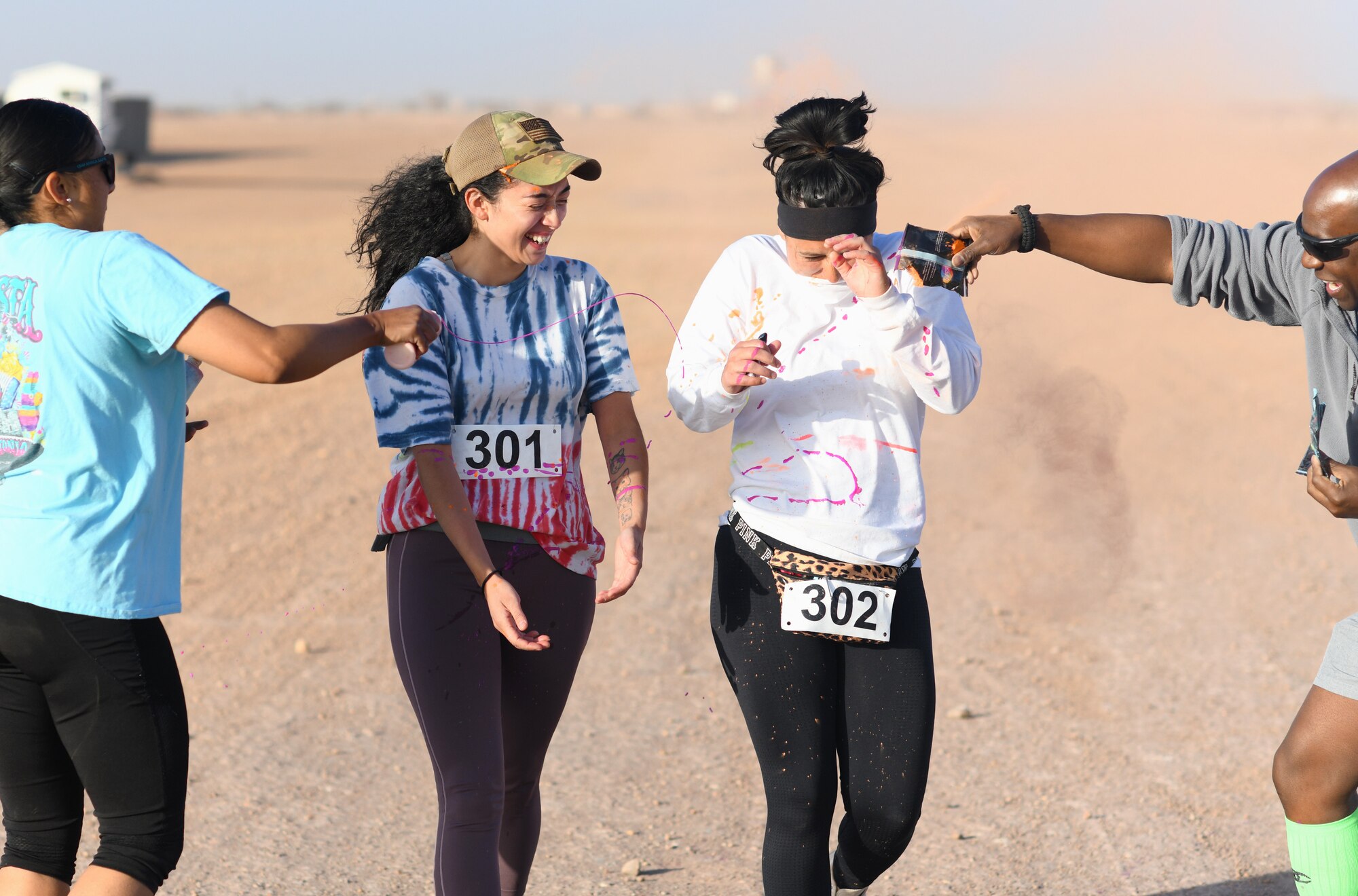 Color run participants run through a gauntlet of paint throwing volunteers at Nigerien Air Base 201, Niger, Feb. 2, 2020. More than 30 runners and volunteers participated in the event. (U.S. Air Force photo by Tech. Sgt. Alex Fox Echols III)