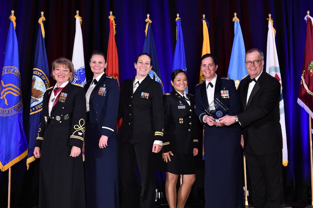 U.S. Central Command’s (USCENTCOM) clinical operations team poses for a group photo during an awards ceremony at the annual meeting of AMSUS, the Society of Federal Health Professionals, Dec. 5 2019. From left to right; U.S. Army Col. Tamara Funari, USCENTCOM’s Chief of Clinical Operations; U.S. Air Force Maj. Steffanie Solberg, U.S. Air Force Central Command’s Chief of Clinical Operations; U.S. Navy Lt. Ashley Hanhurst, Navy Nurse Corps, Walter Reed National Military Medical Center; U.S. Army Cpt. Amanda Roth, microbiologist at US Army Medical Research Directorate – Africa; U.S. Air Force Maj Alice Barsoumian, infectious disease physician at San Antonio Military Medical Center; Thomas McCaffery, Assistant Secretary of Defense for Health Affairs. (Courtesy photo provided by Eddie Arrossi/ AMSUS)