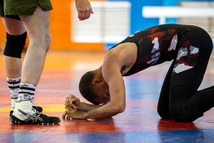 U.S. Navy sailor receives assistance after a match during an open wrestling tournament at the Semper Fit Gym, Feb. 1.