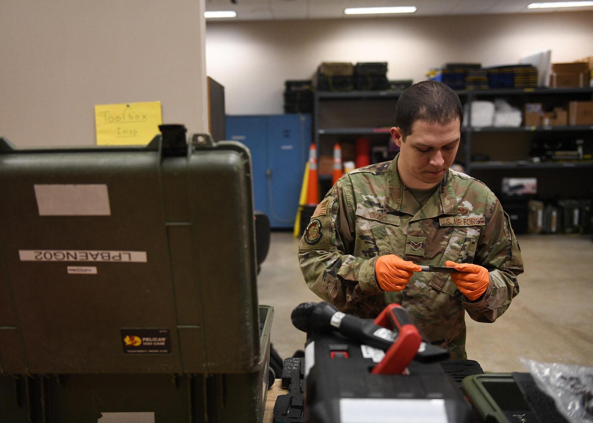 An Airman inspects a small tool.