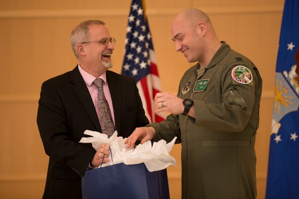 Dr. Michael Gregg (left), director of the Air Force Research Laboratory Aerospace Systems Directorate, presents a gift to guest speaker Capt. Joshua Caudill of the Air National Guard's 112th Fighter Squadron at the directorate’s 8th Annual Awards Luncheon, held Jan. 30, 2020, at the Schuster Performing Arts Center in Dayton, Ohio. (U.S. Air Force Photo/Danielle DeBorde)