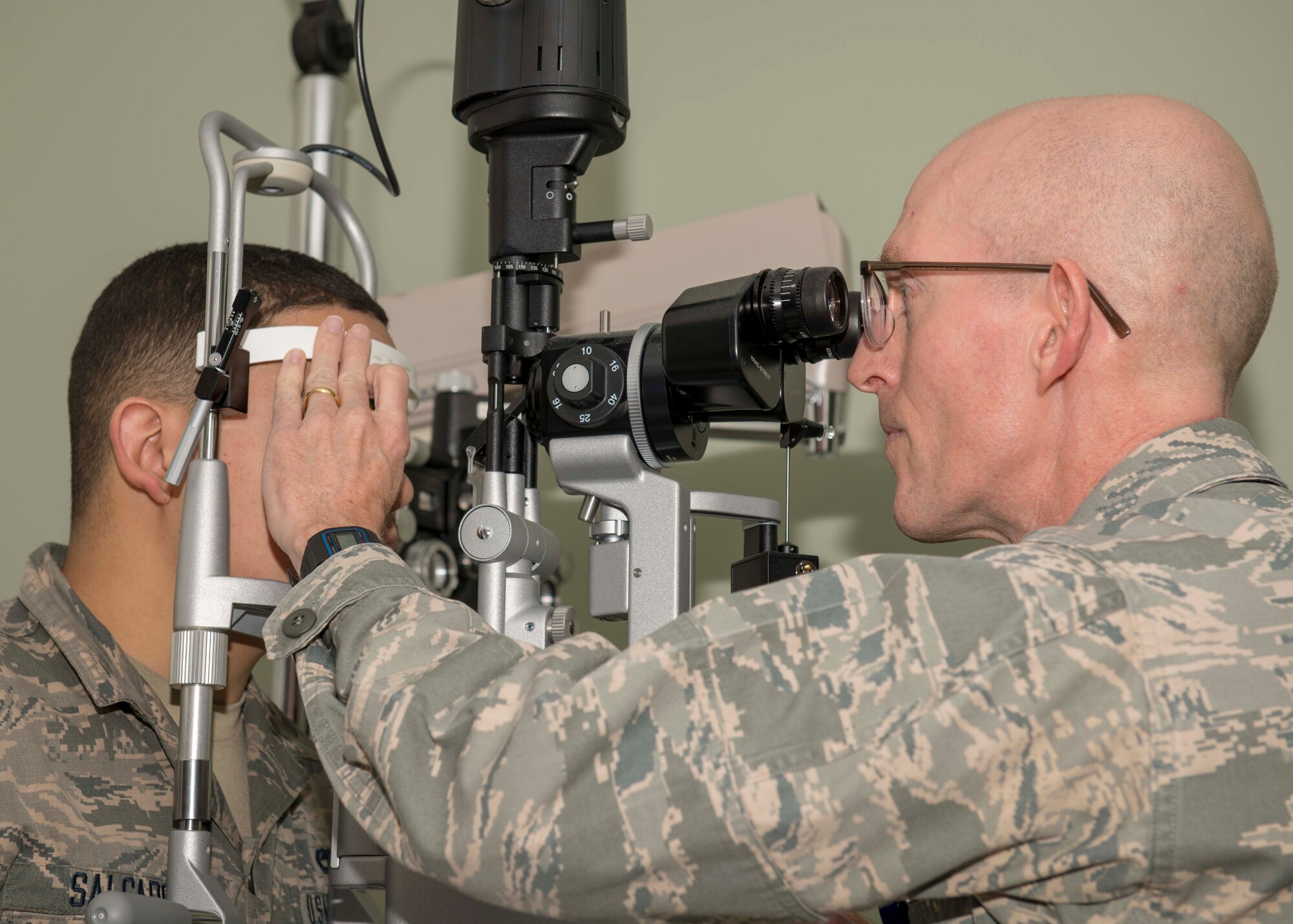 Lt. Col. Steven Weekes, 4th Operational Medical Readiness Squadron optometrist, performs eye exam on Senior Airman Carlos Salgado, 335th Aircraft Maintenance Unit crew chief, using a slit lamp microscope, Jan. 21, 2020, at Seymour Johnson Air Force Base, N.C.