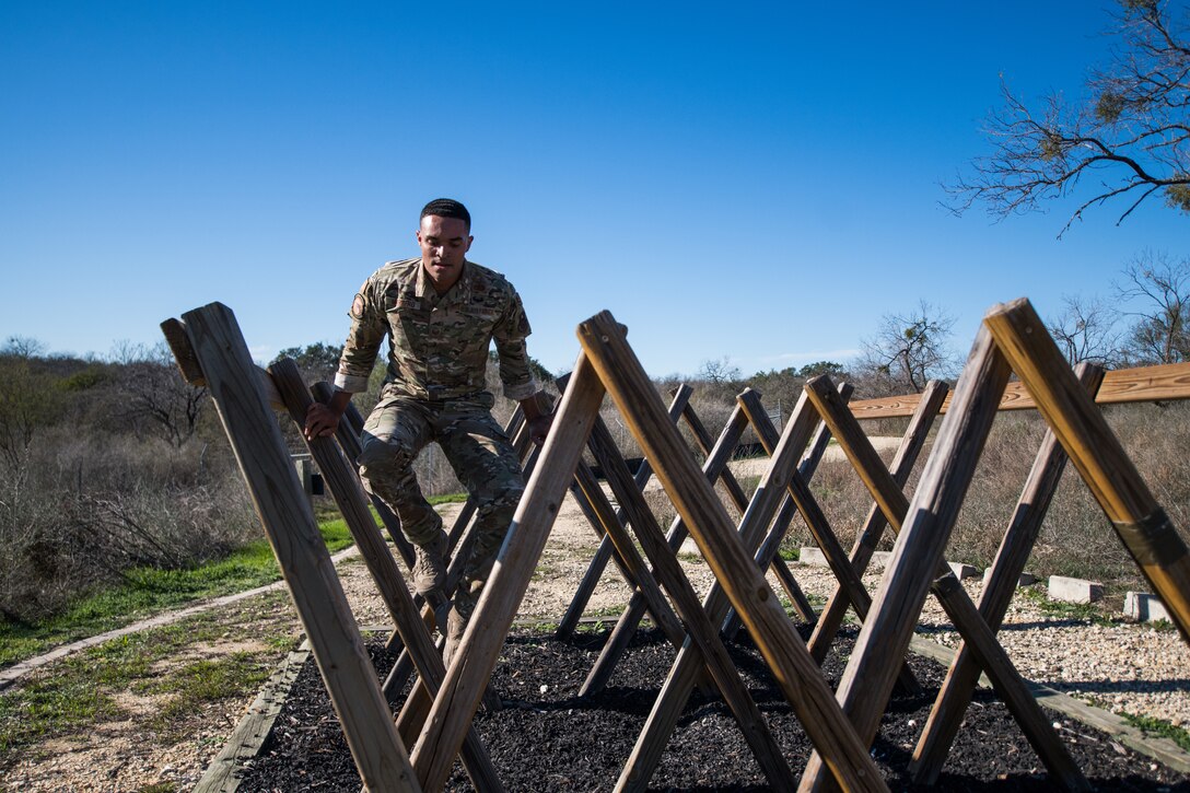 An airman moves through an obstacle.