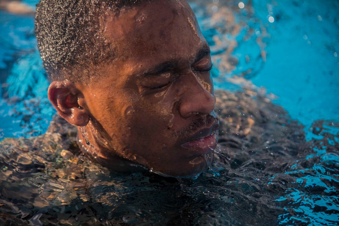 A Marine treads water in a pool.