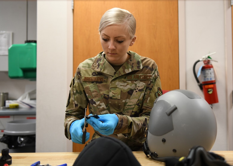 Airman 1st Class Maggie Breedlove, 9th Operations Support aircrew flight equipment specialist, measures and cuts Velcro pieces that will be placed in the inside of a flyers lightweight helmet, Jan. 22, 2020 at Beale Air Force Base, California. These pieces of Velcro will attach an energy absorbing liner to the helmet. The purpose of an energy absorbing liner is to reduce impact energy to the head of a pilot. (U.S. Air Force photo by Airman 1st Class Luis A. Ruiz-Vazquez)