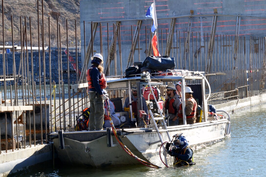 A diver enters the water to assist with the placement of the 10th and final concrete shell on the riverbed of the Tennessee River Feb. 2, 2020 below Kentucky Lock in Grand Rivers, Ky. It is the 10th concrete shell that is part of the permanent downstream lock wall and will double as part of a coffer dam for the Kentucky Lock Addition Project. (USACE photo by Mark Rankin)