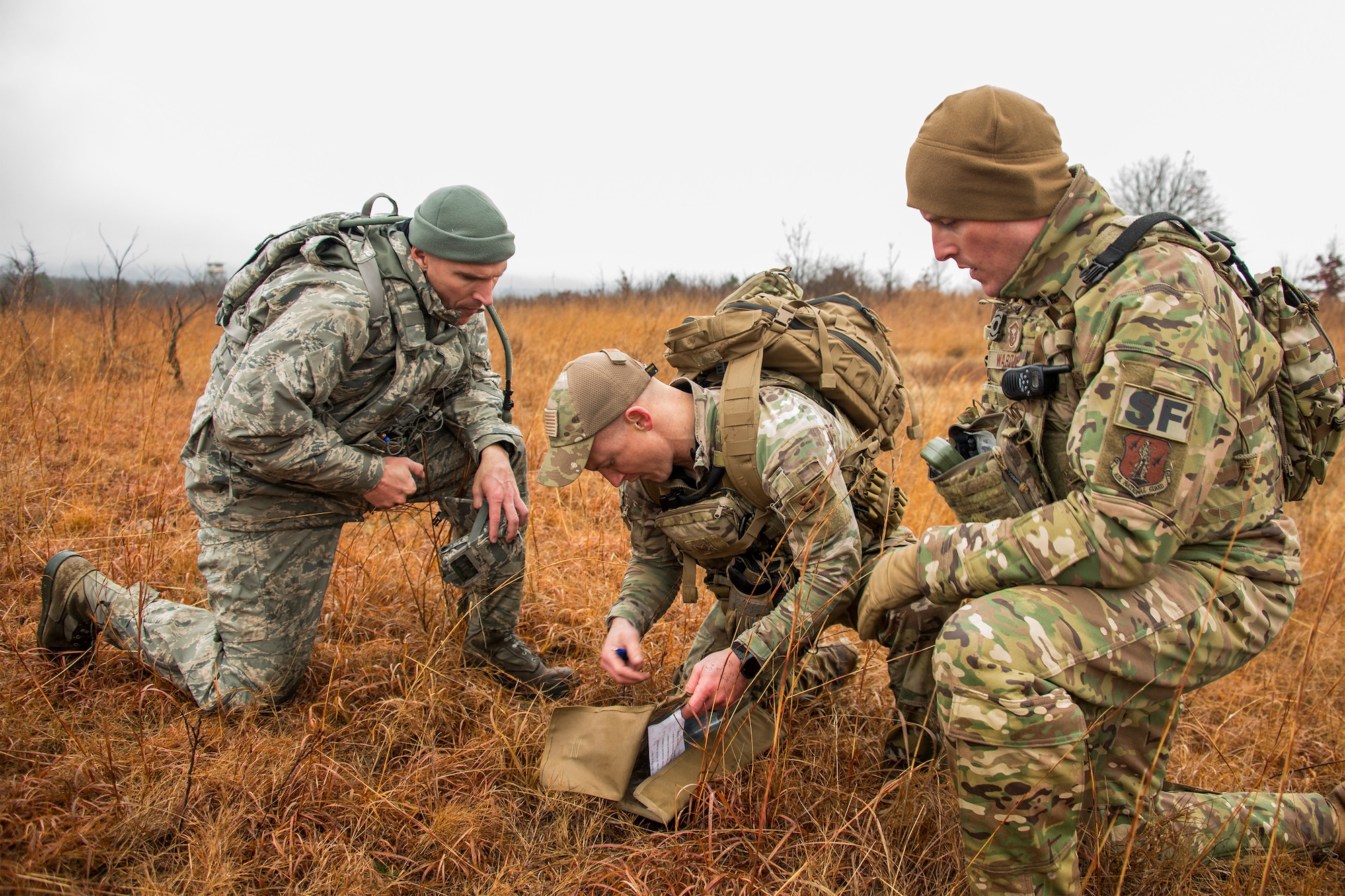 Senior Master Sgt. Bradley Rose, 185th Security Forces Squadron, left, Staff Sgt. Jonathan Finer, 124th SFS, and Master Sgt. Gregory Wardle, 153rd SFS, tackle a land navigation element Jan. 23, 2020, at Fort Chaffee, Arkansas. The team of Airmen from across the Air National Guard gathered to train for the Air Force Defender Challenge, a security forces skills competition held in May at Joint Base San Antonio-Camp Bullis, Texas.