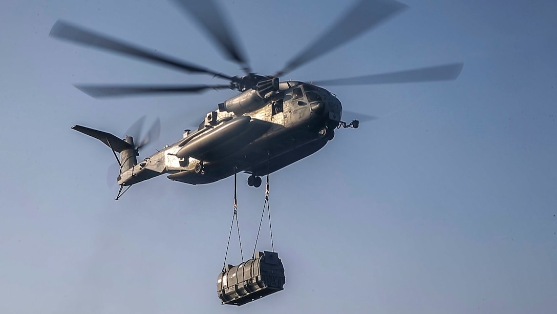 A U.S. Marine Corps CH-53E Super Stallion assigned to Marine Medium Tiltrotor Squadron 365, 26th Marine Expeditionary Unit, transports an AV-8B Harrier engine from the amphibious assault ship USS Bataan (LHD 5). Bataan Amphibious Ready Group, with embarked 26th MEU, is deployed to the U.S. 5th Fleet area of operations in support of maritime security operations to reassure allies and partners and preserve the freedom of navigation and the free flow of commerce in the region. (U.S. Marine Corps photo by Cpl. Tanner Seims)
