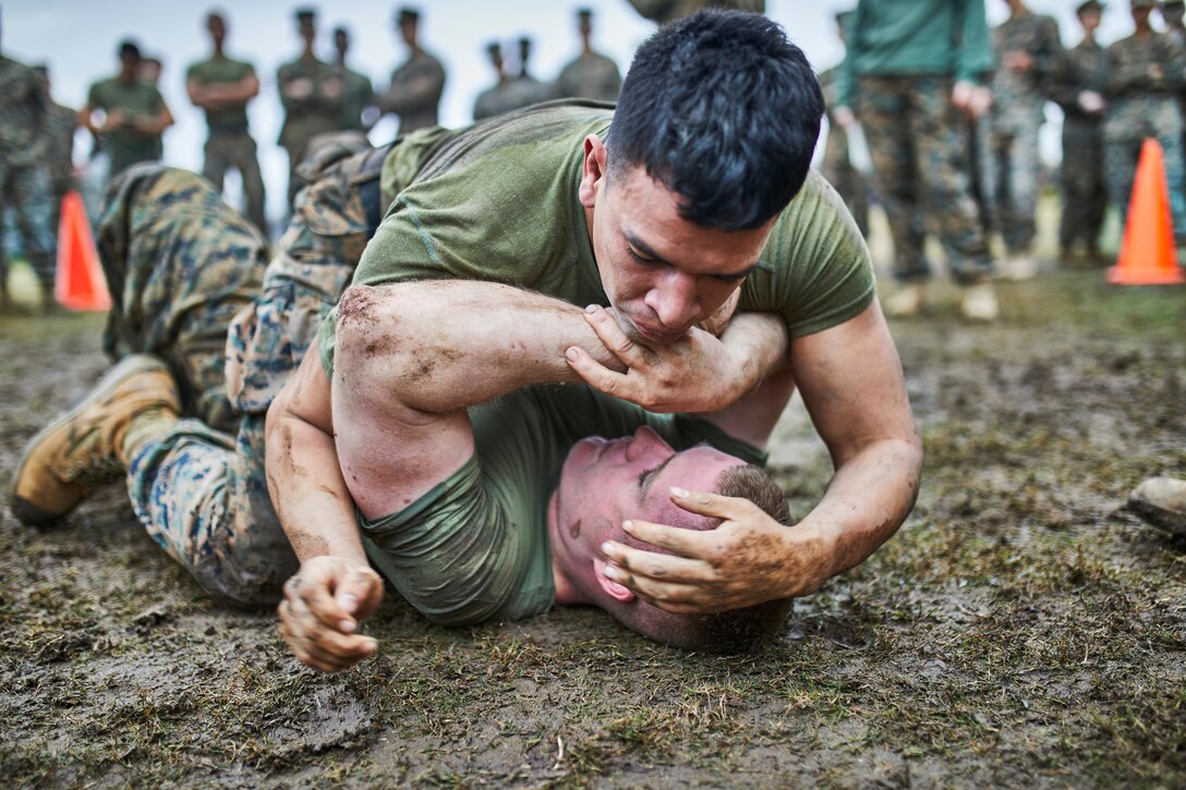 A U.S. Marine with Marine Forces Reserve takes down his opponent during the grappling portion of the King of the Ring tournament at Marine Corps Support Facility New Orleans, Jan. 31, 2020. The tournament challenges competitors to three categories of knife fighting, grappling and baton fighting to become the overall King of the Ring champion. (U.S. Marine Corps photo by Lance Cpl. Leslie Alcaraz)