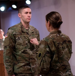 Sgt. 1st Class Larry Groy’s sister, Sgt. Maj. Mary Groy, places his new rank on his uniform during the promotion ceremony Jan. 31 at the Illinois State Military Museum.