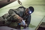 Master Sgt. Eugene Jackson of the 166th Maintenance Squadron, fuel systems maintenance shop, prepares to reseal a leaky fuel system access door on top of the right wing of a C-130H2 aircraft. Because fuel system maintainers have to work in high places, they are required to clip into a safety harness.