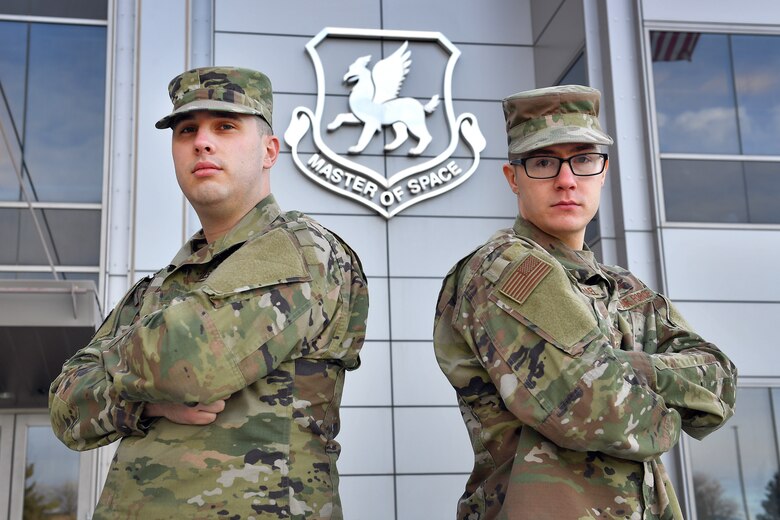 Airmen First Class Joshua Martin, left, and John Carmichael, 50th Comptroller Squadron financial management technicians, pose outside of 50th Space Wing Headquarters Building Jan. 23, 2020. Both Airmen currently work with 50th CPTS financial management but will return to 50th Operations Support Squadron to resume space operator training Feb. 11. (U.S. Air Force photo by Dennis Rogers)