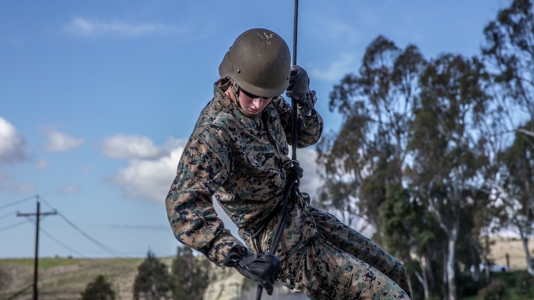 A U.S. Marine reaches to apply his brake during helicopter rope suspension techniques training at the 13 Area rappel tower on Marine Corps Base Camp Pendleton, California, Jan. 22.