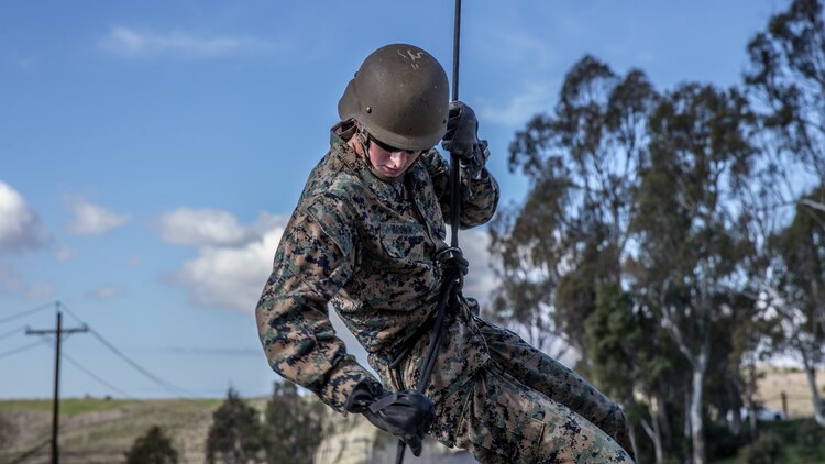 A U.S. Marine reaches to apply his brake during helicopter rope suspension techniques training at the 13 Area rappel tower on Marine Corps Base Camp Pendleton, California, Jan. 22.