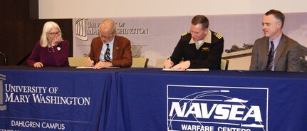 IMAGE: KING GEORGE, Va. (Jan. 31, 2020) – Dr. Troy Paino, University of Mary Washington president, and Capt. Casey Plew, NSWCDD commanding officer, sign a Memorandum of Understanding (MOU) at a ceremony held at the UMW Dahlgren campus, Jan. 31. Looking on are Dr. Nina Mikhalevsky, the university’s provost, and Darren Barnes, NSWCDD acting technical director, who were also MOU signatories. The MOU enables NSWCDD employees who qualify for the program to earn a project management certificate while applying the credits towards a Master of Business Administration. “We are delighted about this opportunity and hold it up as a shining example of the partnerships we are pursuing,” said Barnes. “It would not be possible without the University of Mary Washington.” (U.S. Navy photo/Released)