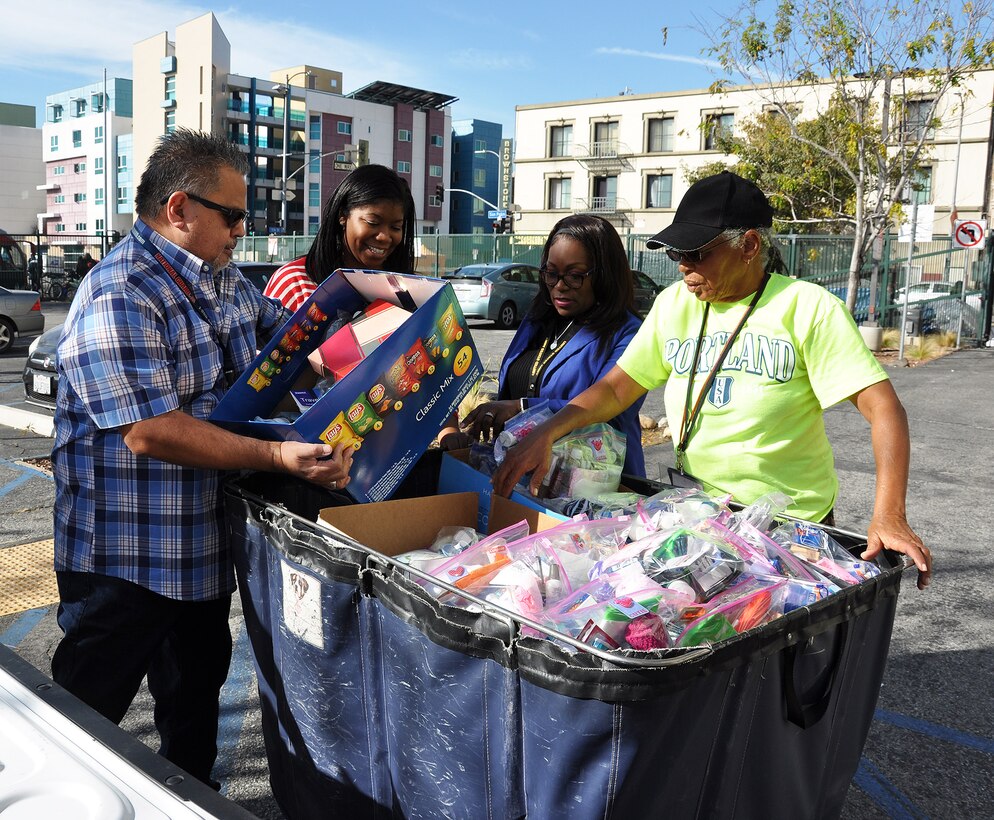 From left to right, Gerry Salas, environmental engineer; Arnecia Williams, regional value officer, Engineering Division; Felicia Weaver, administrative assistant, Public Affairs, all with the U.S. Army Corps of Engineers Los Angeles District, and Pauline Williams, parking attendant at the Downtown Women’s Center, Los Angeles, unload boxes of toiletries into a large cart Jan. 23 at the women’s center in Los Angeles.