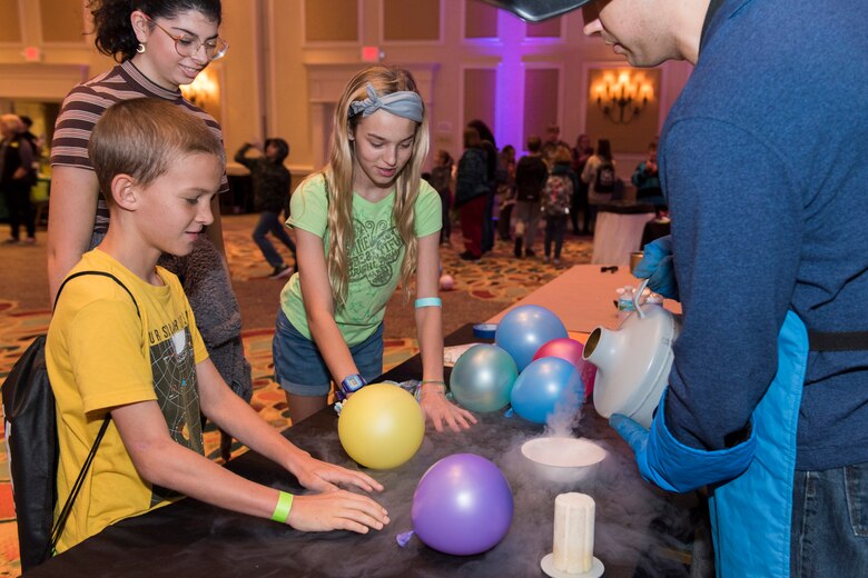 Tech. Sgt. Steven Blake, a member of the Air Force Technical Applications Center at Patrick AFB, Fla., pours liquid nitrogen into a bowl to freeze balloons to illustrate to local school students how the difference in temperatures changes malleable objects into brittle ones during the 2020 Women in Science and Engineering Symposium Jan. 21-23, 2020.  (U.S. Air Force photo by Matthew S. Jurgens)