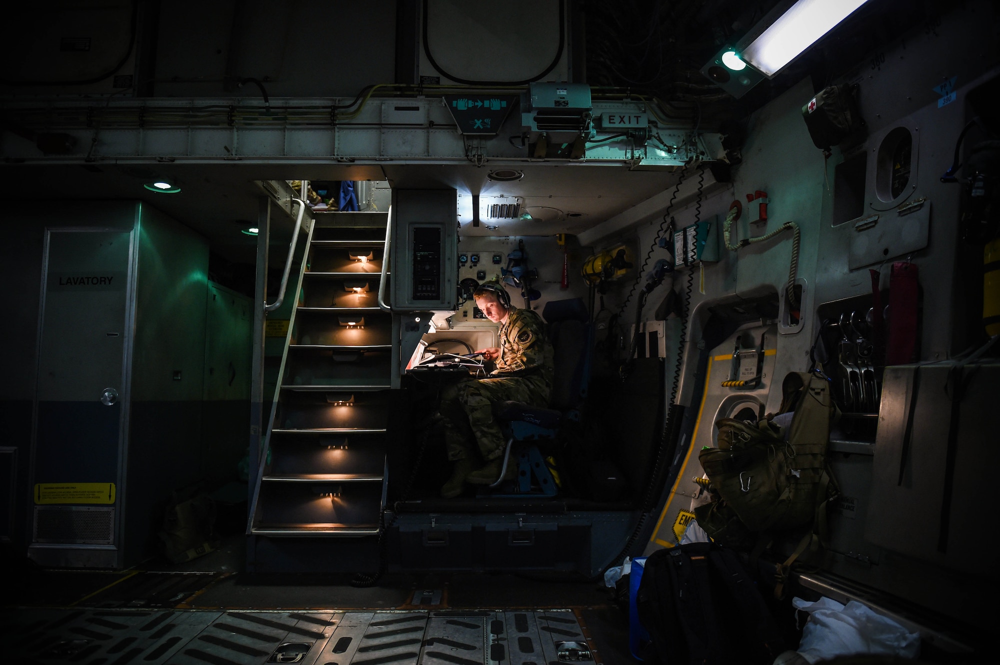 Airman 1st Class Kam Watt, 4th Airlift Squadron loadmaster, looks over a pre-flight checklist inside a C-17 Globemaster III before taking off from Iraq, Dec. 20, 2019. Loadmasters communicate with pilots upstairs in the flight deck via radio communications headsets. (U.S. Air Force photo by Airman 1st Class Mikayla Heineck)