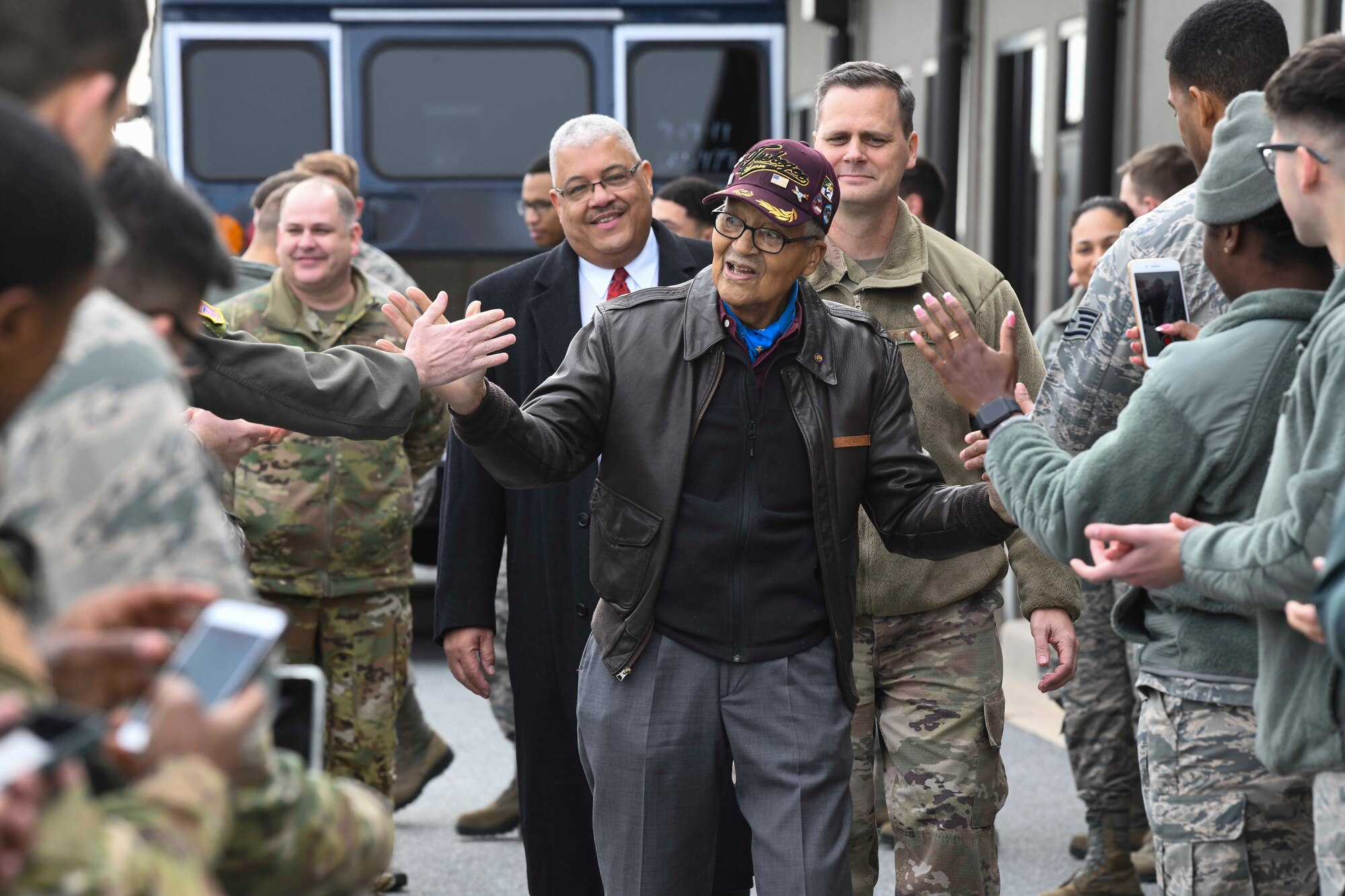Retired Col. Charles McGee, one of the Tuskegee Airmen, high-fives Airmen during his visit Dec. 6, 2019, at Dover Air Force Base, Del. McGee served a total of 30 years in the U.S. Air Force, beginning with the U.S. Army Air Corps, and flew a total of 409 combat missions in World War II, the Korean War and the Vietnam War. The Tuskegee Airmen were the first African-American military aviators in the U.S. Army Air Corps. (U.S. Air Force photo by Senior Airman Christopher Quail)