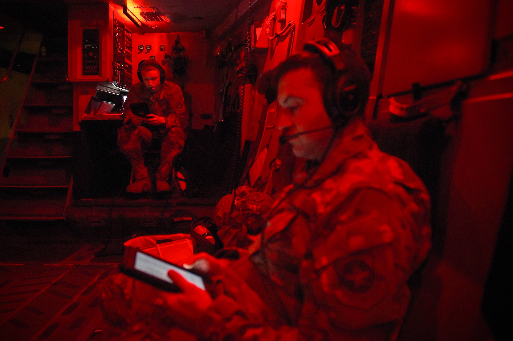 Airman 1st Class Kam Watt, left, and Master Sgt. Andrew Reilly, 4th Airlift Squadron loadmasters, review loadmaster Air Force Instructions (AFIs) aboard a C-17 Globemaster III in flight Dec. 18, 2019. Loadmasters don’t have career development courses (CDCs) like some Air Force career fields, instead, they rely primarily on the guidelines laid out in the AFIs and flight manuals. (U.S. Air Force photo by Airman 1st Class Mikayla Heineck)