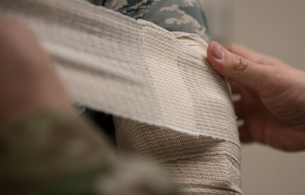 A U.S. Air Force medic practices applying bandages at Joint Base Langley-Eustis, Virginia, January 22, 2020. The Tactical Combat Care Course is a way of standardizing what skills medics are learning across the U.S. military. (U.S. Air Force photo by Airman 1st Class Sarah Dowe)
