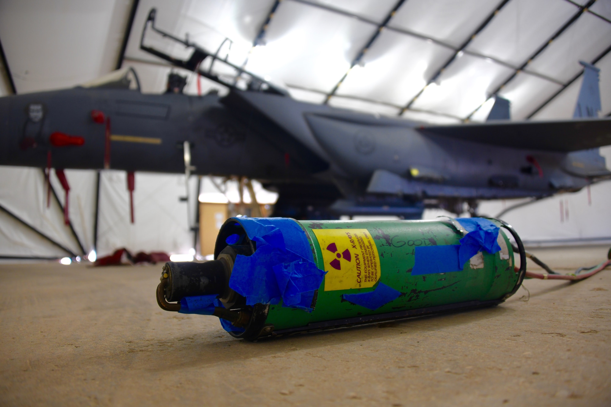 An X-ray device sits in front of an F-15E Strike Eagle prior to a nondestructive inspection, at Prince Sultan Air Base, Kingdom of Saudi Arabia, Feb. 3, 2020.