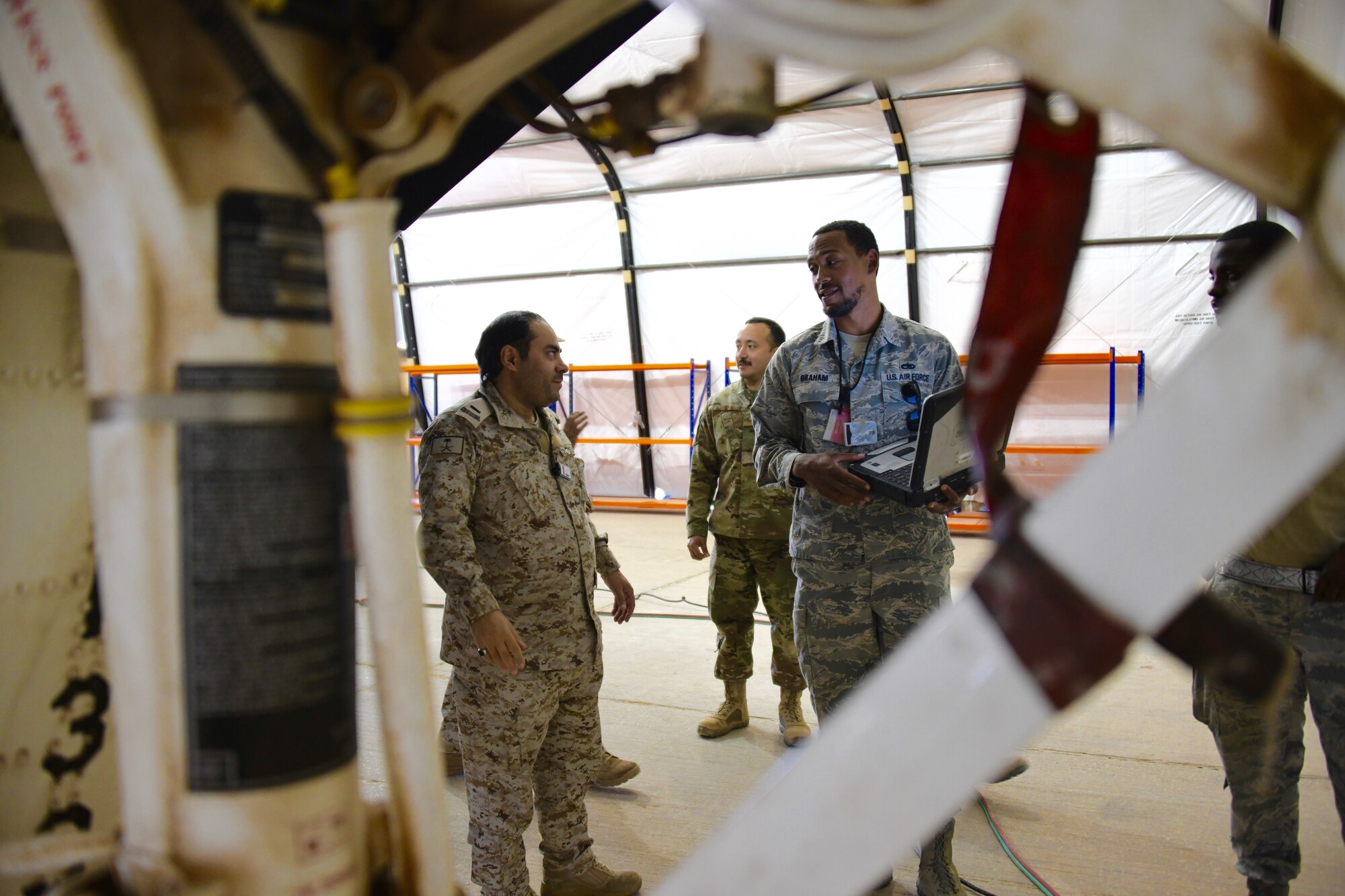 U.S. Air Force Tech. Sgt. Chris Graham (right), 378th Expeditionary Maintenance Squadron nondestructive inspection noncommissioned officer in charge, talks to Royal Saudi Air Force Chief Salman D. Al-Malki , PSAB head of aircraft maintenance inspections, about the processes of inspecting an F-15E Strike Eagle at Prince Sultan Air Base, Kingdom of Saudi Arabia, Feb. 4, 2020.