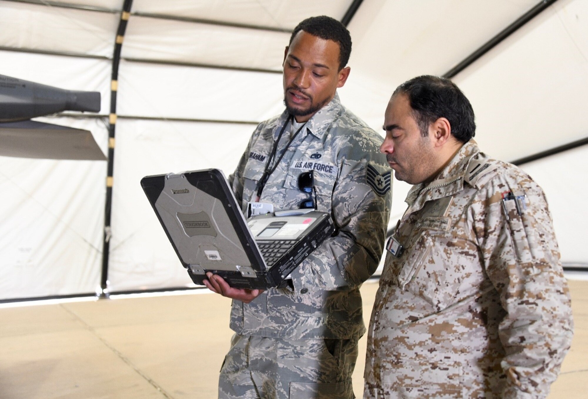 U.S. Air Force Tech. Sgt. Chris Graham (left), 378th Expeditionary Maintenance Squadron nondestructive inspection noncommissioned officer in charge, talks to Royal Saudi Air Force Chief Salman D. Al-Malki , PSAB head of aircraft maintenance inspections, about the processes of inspecting an F-15E Strike Eagle at Prince Sultan Air Base, Kingdom of Saudi Arabia, Feb. 4, 2020.