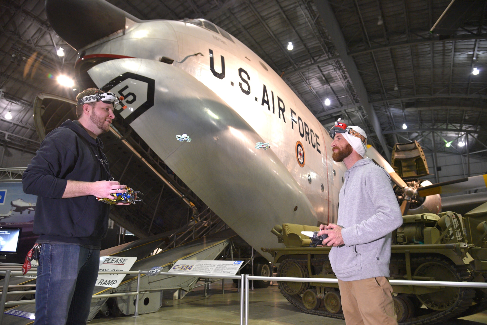 Two Micro drone pilots flying their drones inside the museum