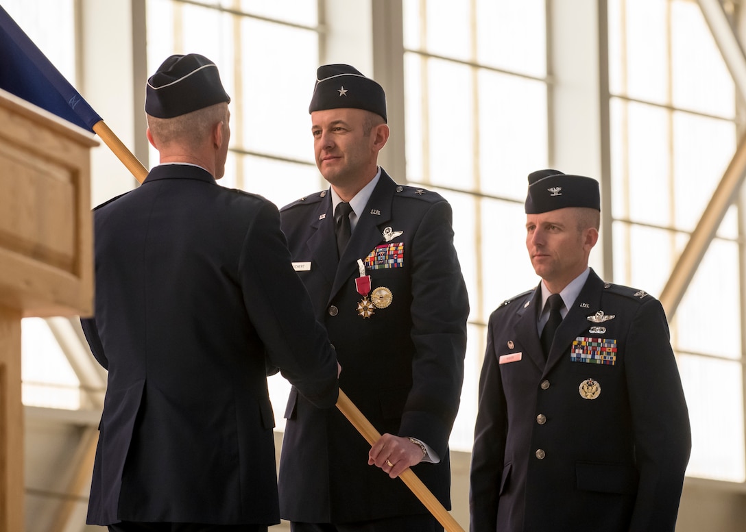 Brig. Gen. E. John Teichert, the outgoing 412th Test Wing Commander, relinquishes his command of the Wing by returning the unit’s guidon to Maj. Gen. Christopher Azzano, Air Force Test Center Commander, during the Wing’s Change of Command Ceremony at Edwards Air Force Base, California, Feb. 5. (Air Force photo by Giancarlo Casem)