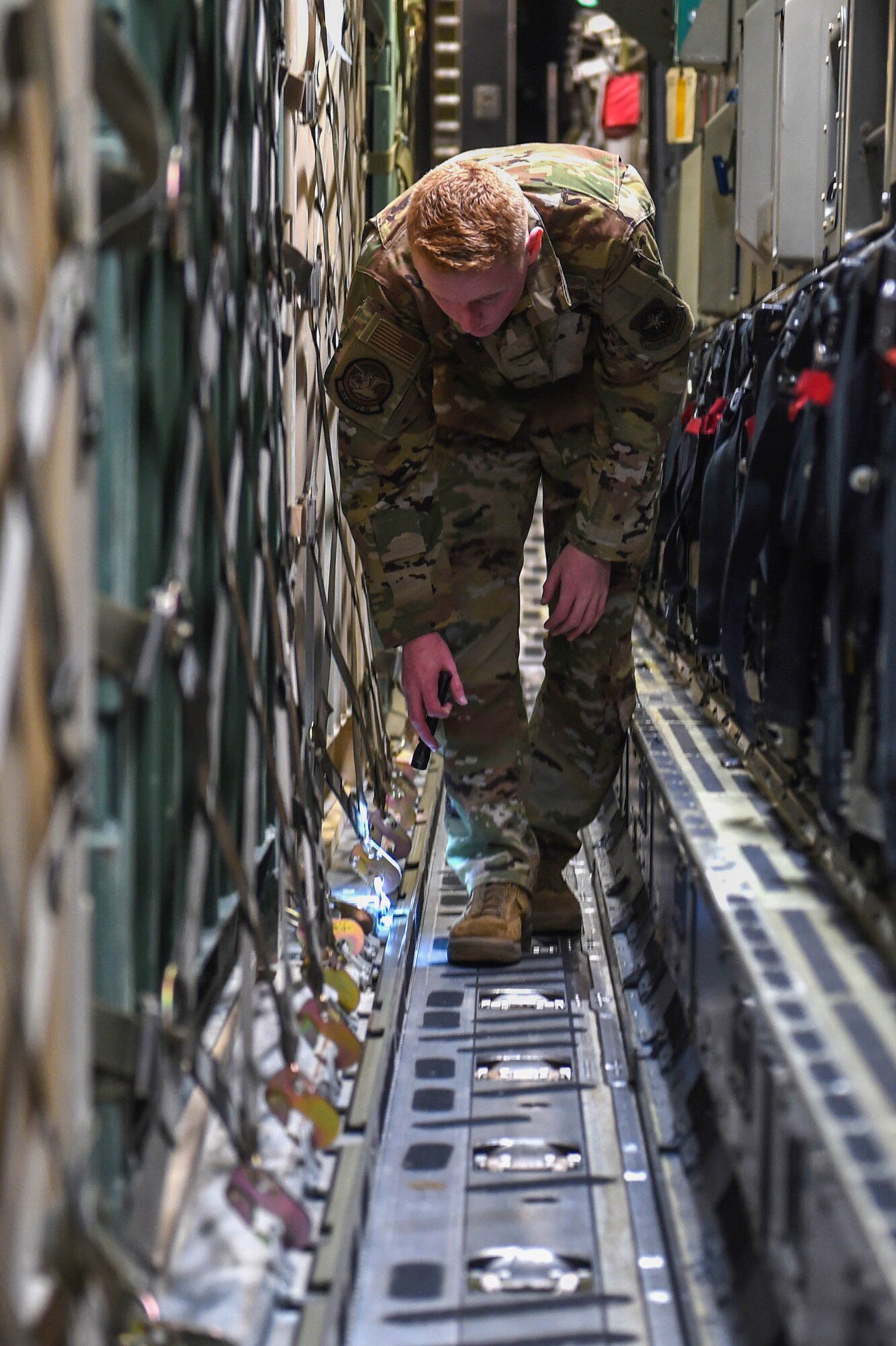 Airman 1st Class Kam Watt, 4th Airlift Squadron loadmaster, double checks the secure netting of pallets of cargo aboard a C-17 Globemaster III as part of the pre-flight checklist before taking off from Spangdahlem Air Base, Germany, Dec. 18, 2019. Loadmasters are responsible for ensuring the security of cargo and proper weight distribution. (U.S. Air Force photo by Airman 1st Class Mikayla Heineck)