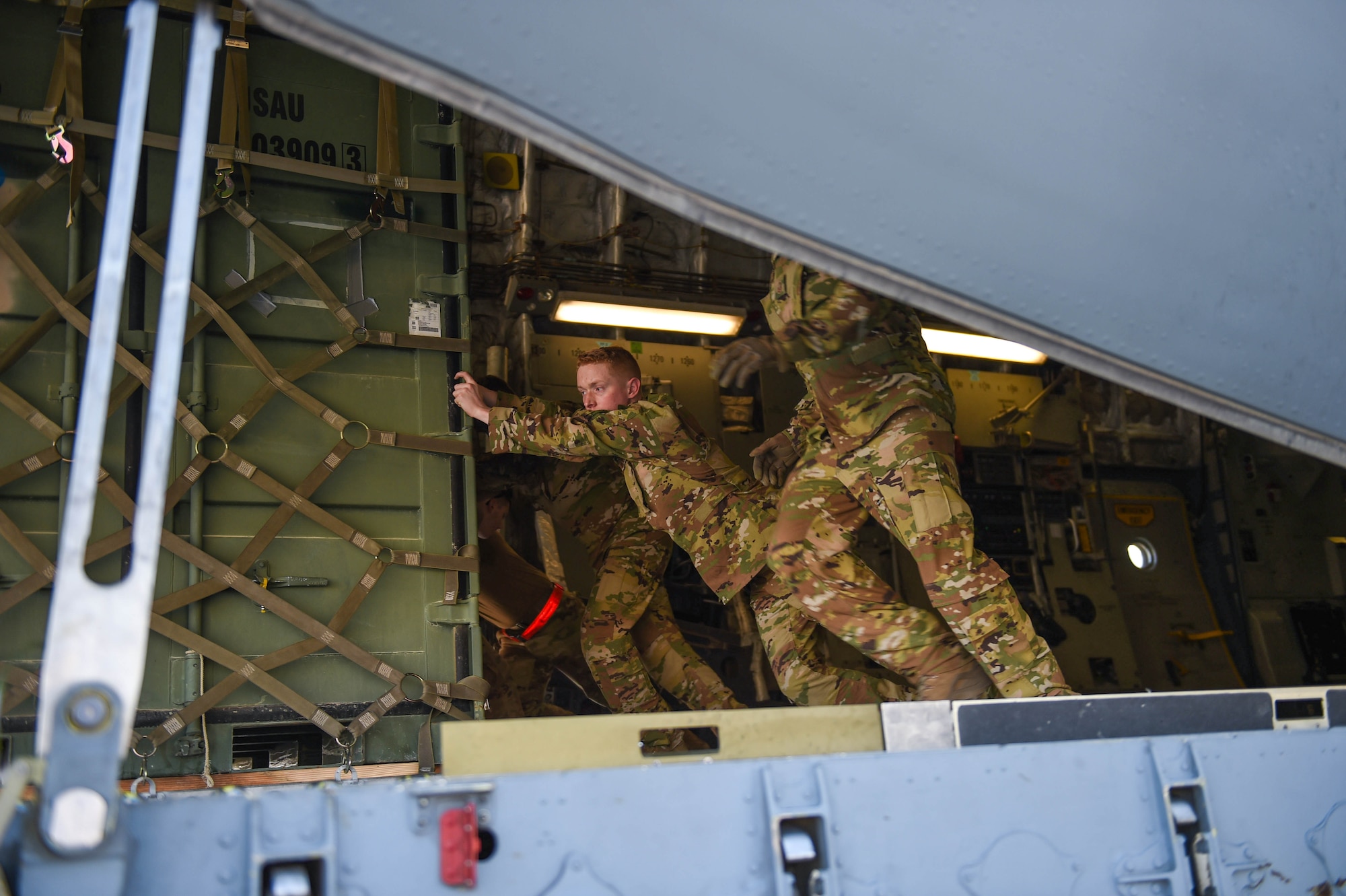 Airman 1st Class Kam Watt, 4th Airlift Squadron loadmaster, off-loads a piece of cargo off of a C-17 Globemaster III onto a K-loader in Kuwait, Dec. 18, 2019. The aircraft has multi-directional rollers towards the back of the cargo bay that make it easier to push and maneuver cargo. (U.S. Air Force photo by Airman 1st Class Mikayla Heineck)