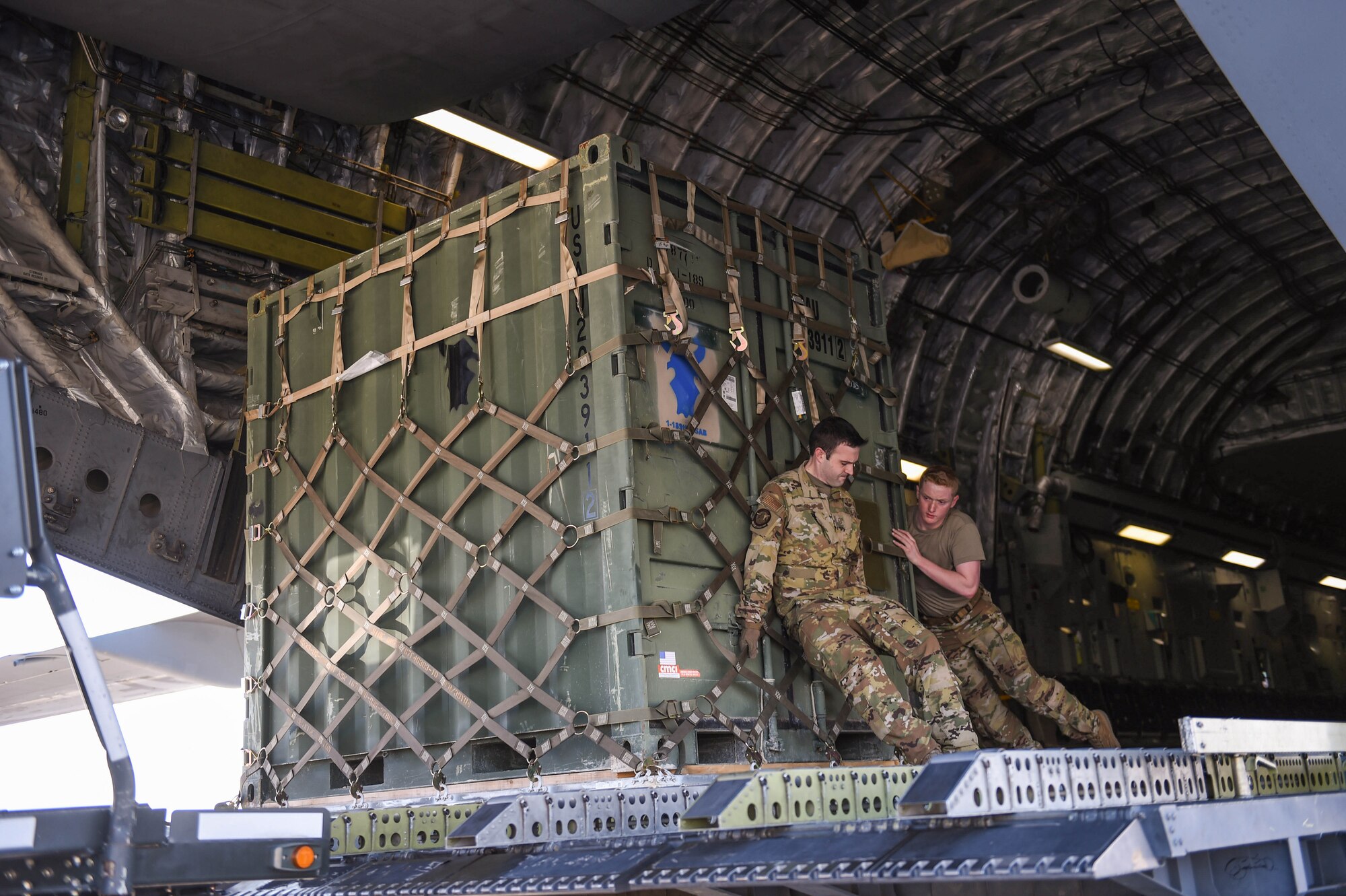 Master Sgt. Andrew Reilly and Airman 1st Class Kam Watt, 4th Airlift Squadron loadmasters, offload a piece of cargo from a C-17 Globemaster III in Kuwait, Dec. 18, 2019. The C-17 is eqipped with multi-directional rollers in the floor to aid in the on and off-load of cargo. (U.S. Air Force photo by Airman 1st Class Mikayla Heineck)