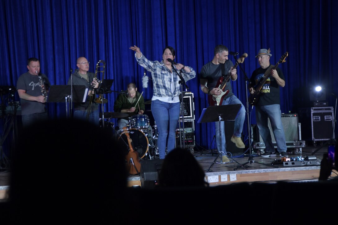 Tech. Sgt. Amy Chicavich and Airman 1st Class Jonathan Delise, Air Forces Central Command Band members, perform for deployed members in The Rock theater at Ali Al Salem Air Base, Kuwait January 3, 2020. These dynamic musicians perform and tour in small ensembles throughout the AOR to positively promote troop morale, diplomacy and outreach to host nation communities. (U.S. Air Force photo by Tech. Sgt. Alexandre Montes)