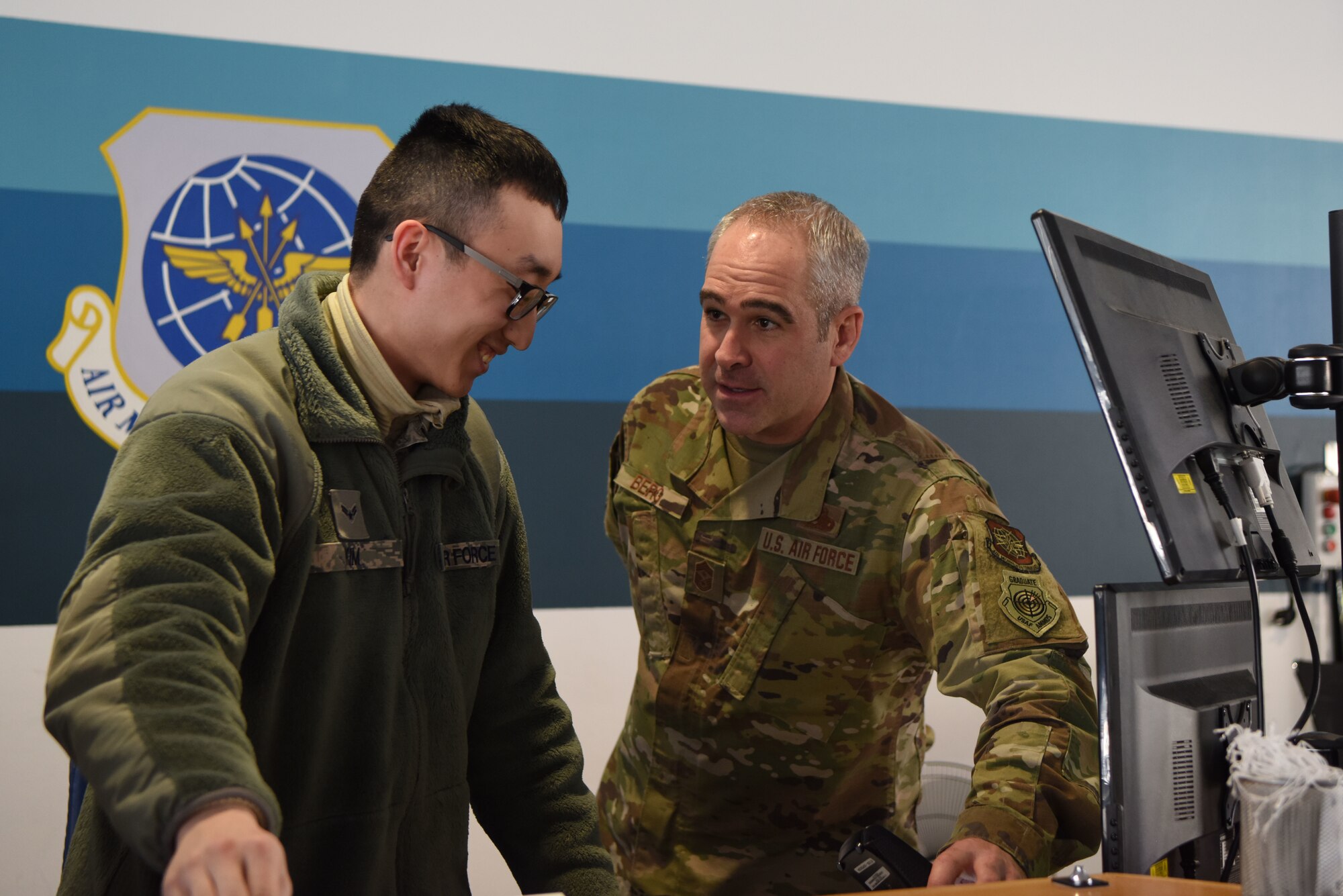 Chief Master Sgt. Kristopher Berg, Air Force Expeditionary Center command chief, interacts with Airman 1st Class Samuel Kim 721st Aerial Port Squadron passenger service agent, during a 521st Air Mobility Operations Wing visit at Ramstein Air Base, Germany, Jan. 29, 2020. The Expeditionary Center provides direct oversight for the global en-route system, which provides the U.S. with a worldwide, force-accelerating, power projection platform from 26 airfields across 23 countries.