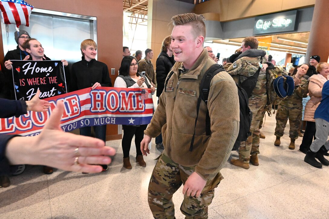Photo of Senior Airman Alexander Nienas being welcomed at Hector International Airport, Fargo, N.D., upon his completion of deployment Feb. 5, 2020.