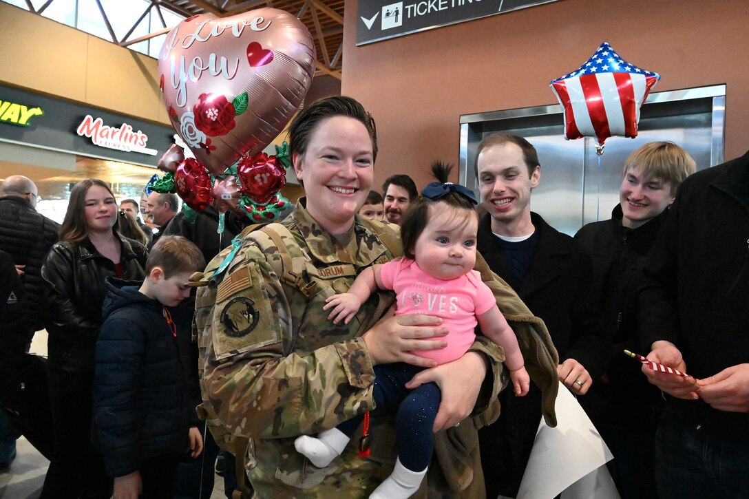 Photo of Staff Sgt. Alyssa Sorum being greeted by family and friends as she arrives at Hector International Airport, Fargo, N.D., upon her completion of six-month deployment Feb. 5, 2020.
